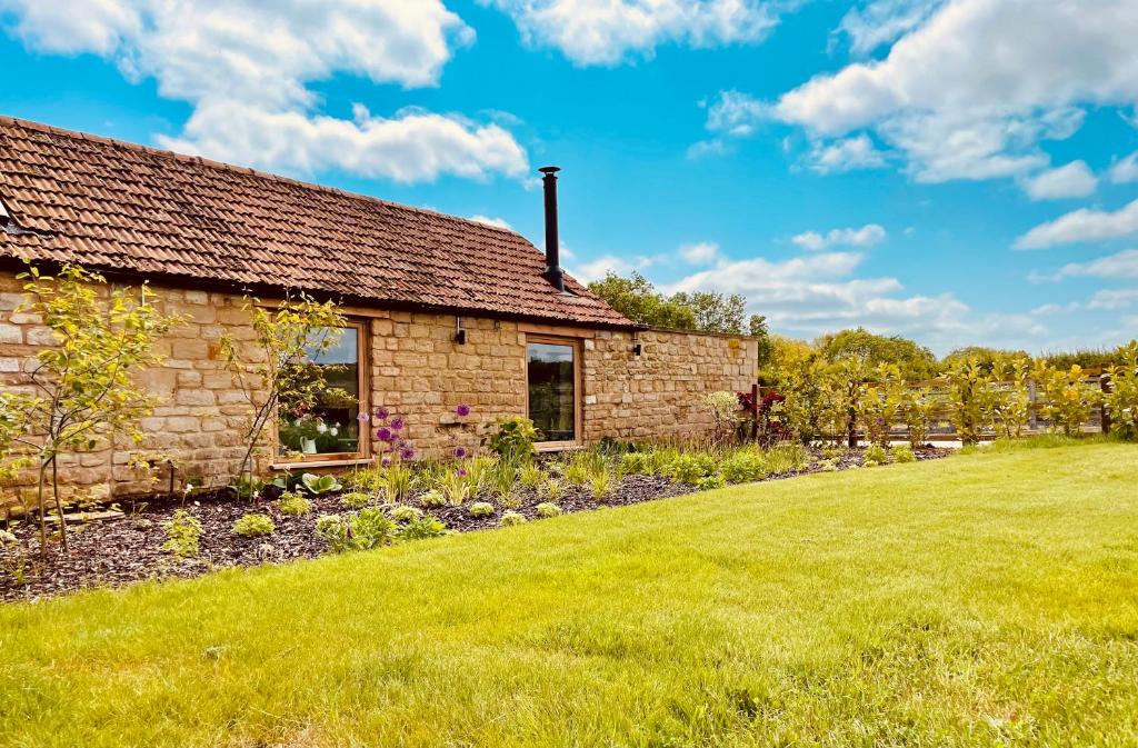 a stone house with a lawn in front of it at The Cow Shed - Rural Barn Conversion in Little Bytham