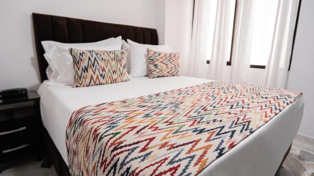 Giường trong phòng chung tại Hotel Arisha Cali