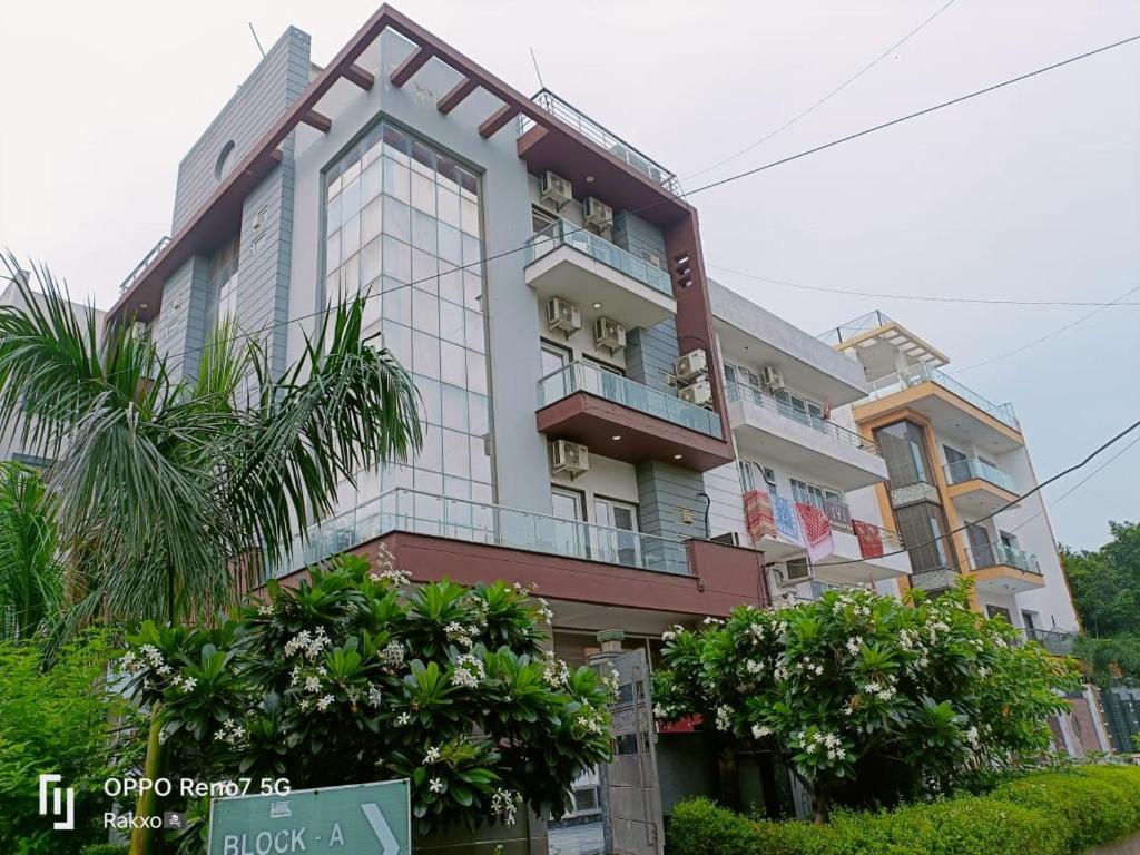 um edifício alto com árvores em frente em The Grand Suite-70 em Noida