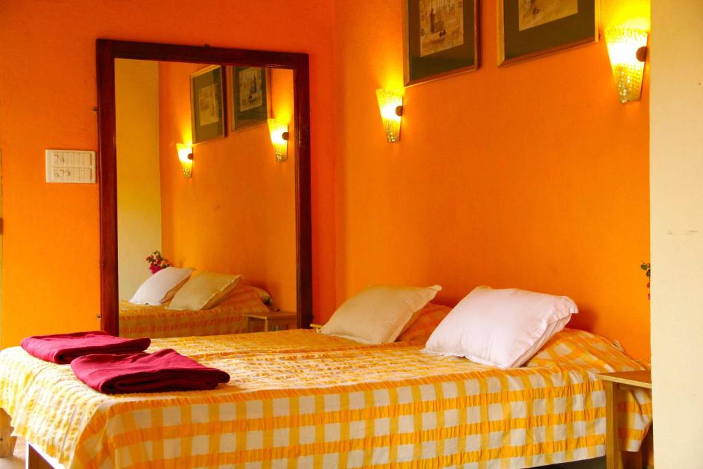 a bedroom with two beds and a mirror at Michèle's Garden in Anjuna
