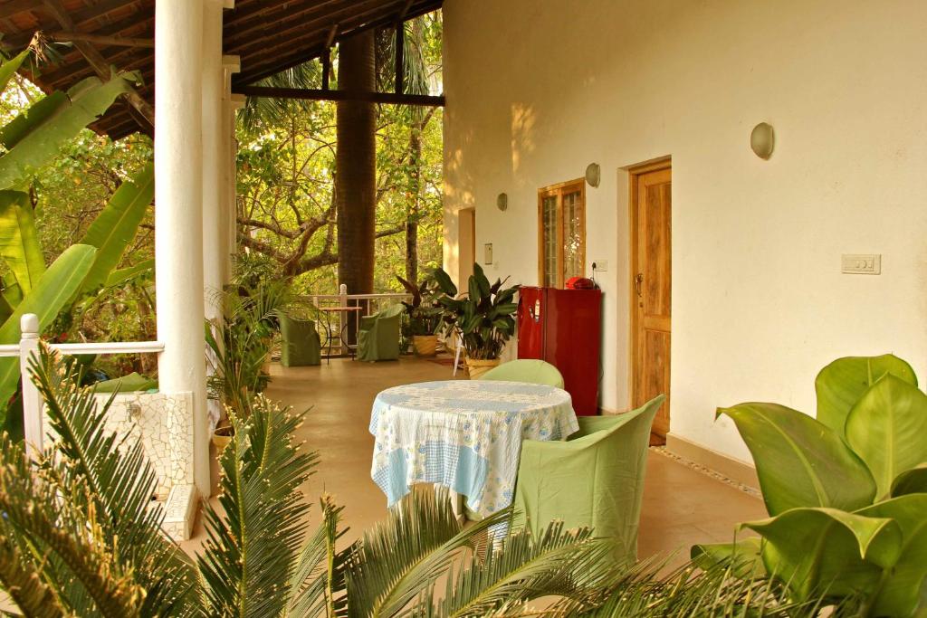 a patio with a table and some plants at Michèle's Garden in Anjuna
