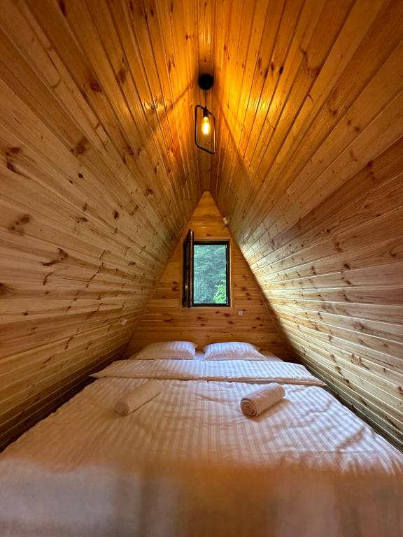 Cama grande en habitación de madera con ventana en Glacier Shoda, en Ghebi