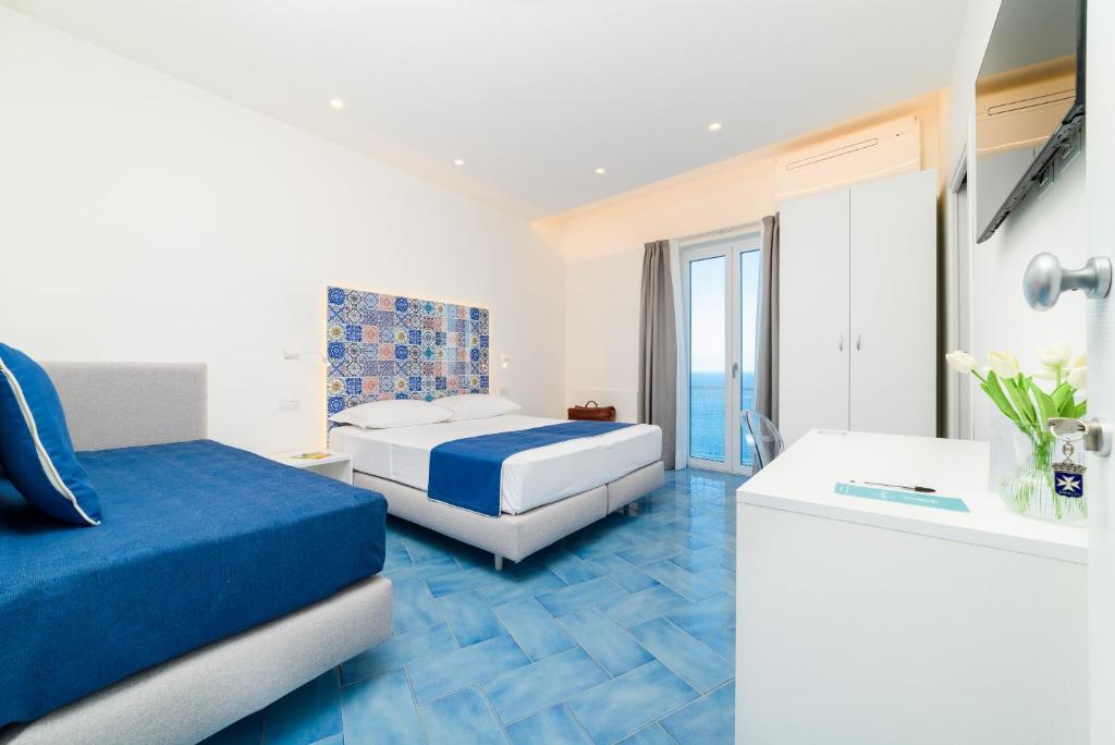 een hotelkamer met 2 bedden en een balkon bij Eden sul Mare in Amalfi