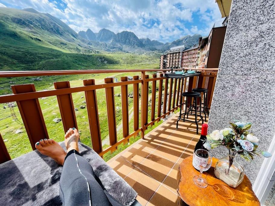 a person laying on a balcony with a bottle of wine at Estudio”CasaTeva”(PIEpista-Vistas-Wiffi-Netflix…) in Pas de la Casa