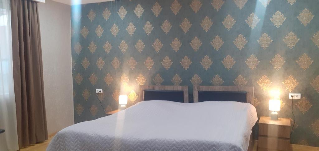 sypialnia z białym łóżkiem i zieloną ścianą w obiekcie Kaxa Shorena Guest-House w mieście Stepancminda