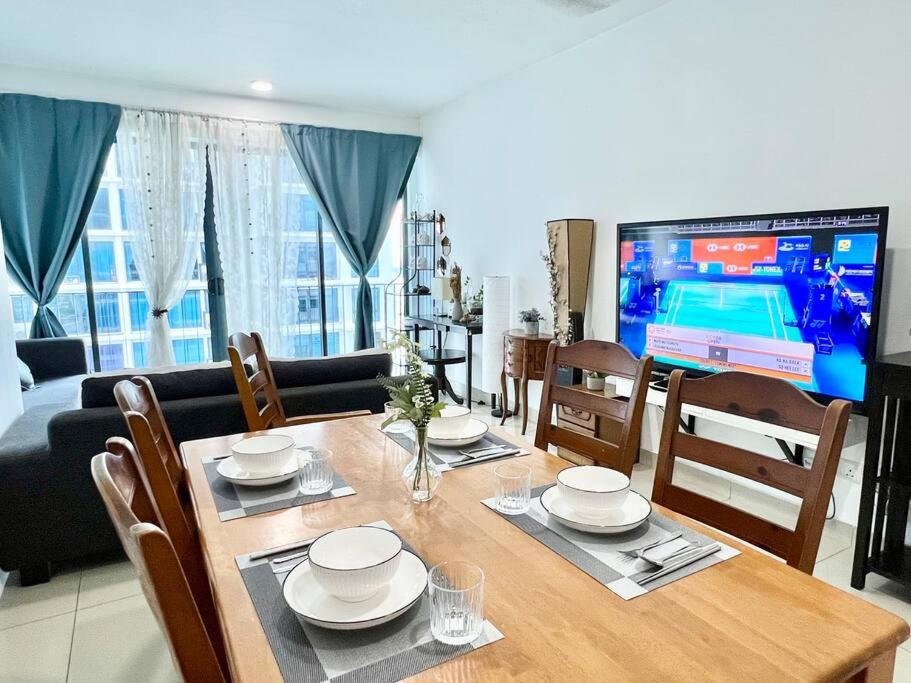 a dining table with chairs and a television in a living room at T2 1-10Pax 2Room Balcony Trefoil Setia Alam TV Wi-Fi in Shah Alam