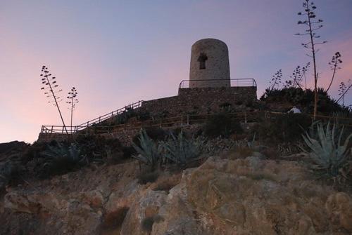 um farol no topo de uma colina com plantas em La Casilla: Casa acogedora a los pies de la Atalaya. em Níjar