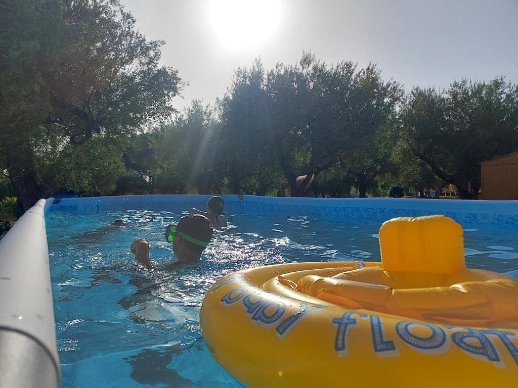 dos niños jugando en una piscina con una balsa inflable en Parco Esmeralda - Family Residence e Breakfast en Marina di Camerota