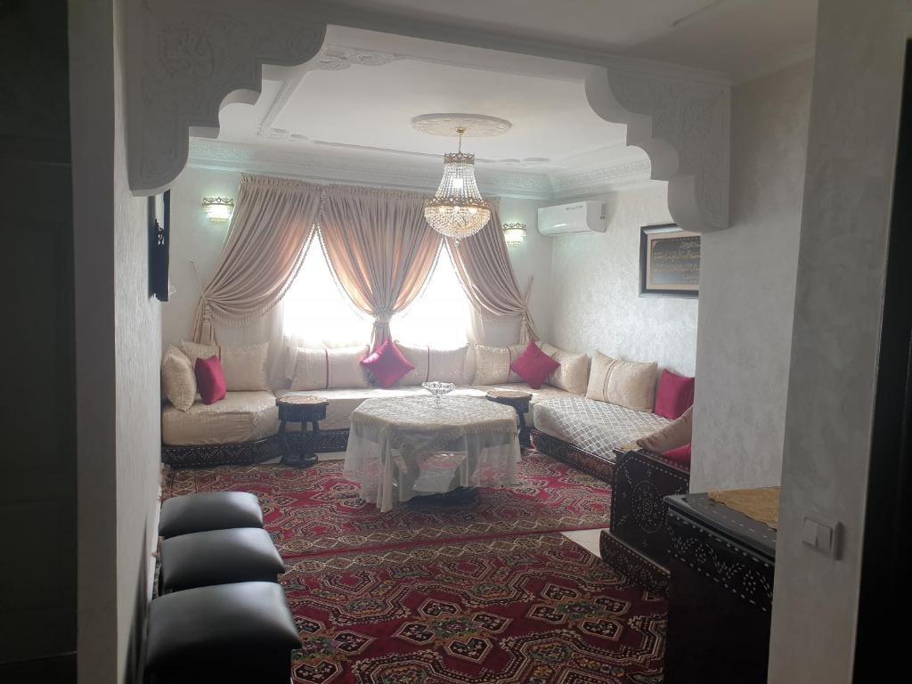 a living room with a couch and a table at Appartement Meublé AIN SEBAA in Aïn Sebaa