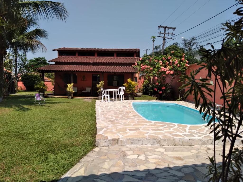 einen Hinterhof mit einem Pool und einem Haus in der Unterkunft Guapimirim Casa de Campo in Guapimirim