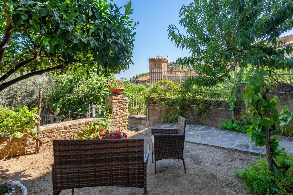 un patio con 2 sillas y una mesa en un jardín en Borgo Dominici, en Ortodonico