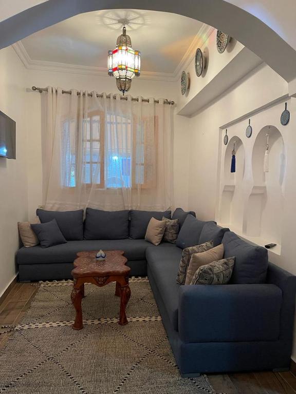 a living room with a blue couch and a table at Casa Hassan in Asilah