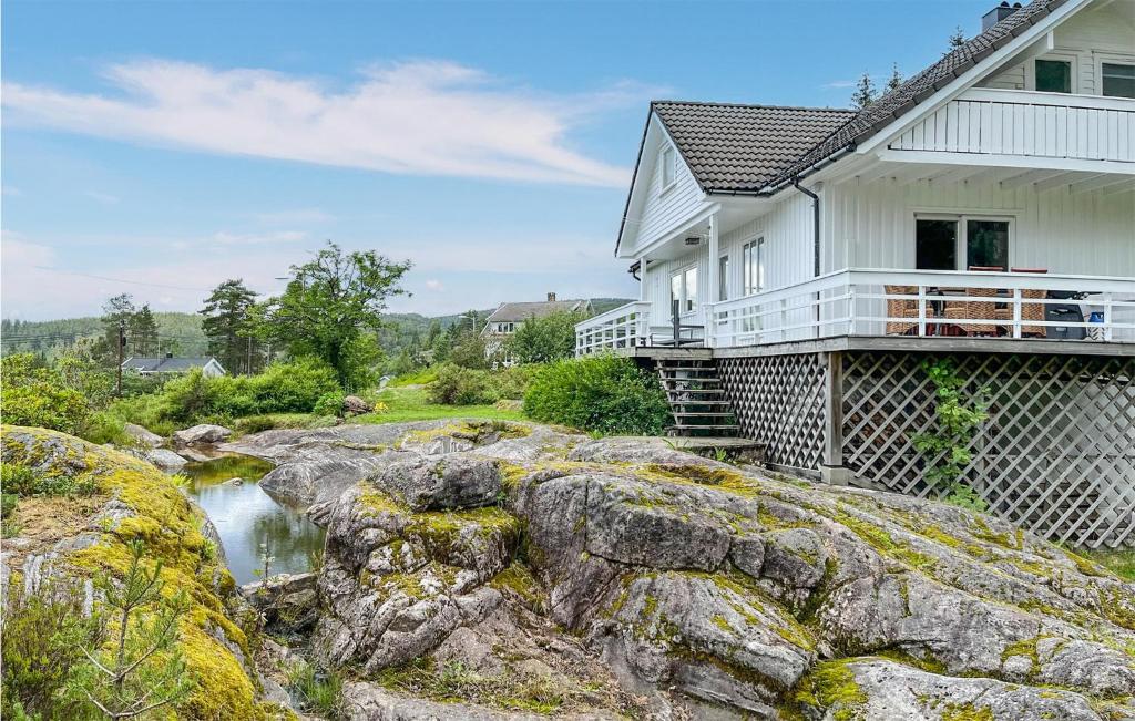 a house sitting on top of rocks next to a river at Beautiful Home In Kollungtveit With Wifi 