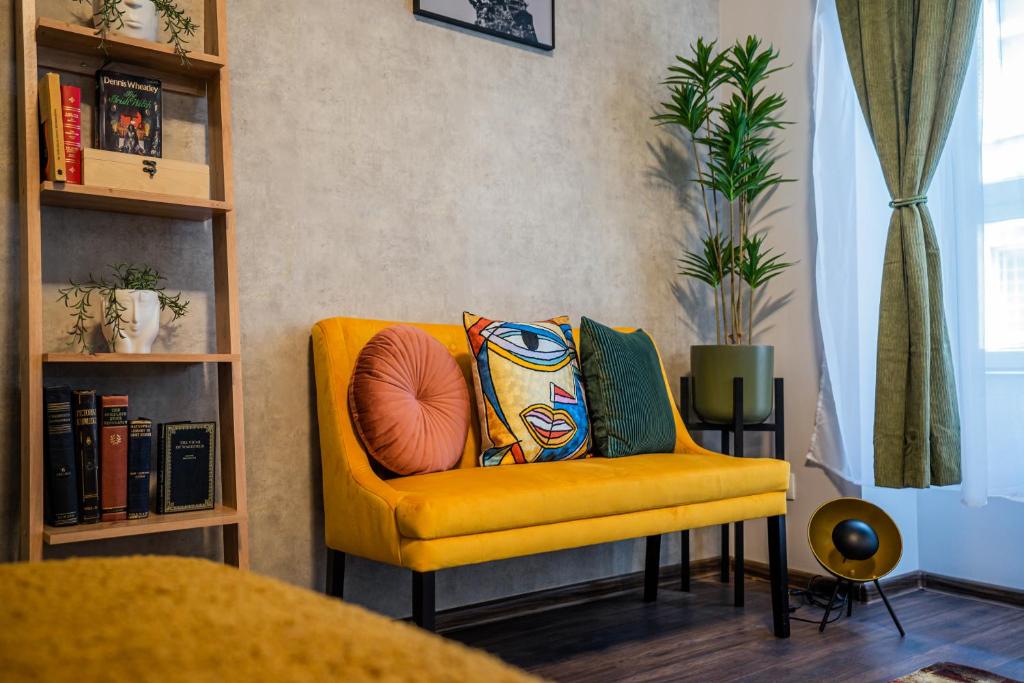 a yellow chair with a pillow on it in a room at Colors of Budapest in Budapest