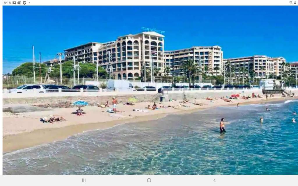 Un homme debout dans l'eau à la plage dans l'établissement Mer et commerces 2 lits 1p 483, à Cannes