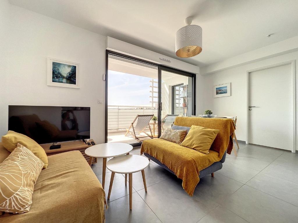 ein Wohnzimmer mit einem Sofa und einem Tisch in der Unterkunft Le Balcon du Panier - Central - Climatisation - Les Frères de la Loc' in Marseille