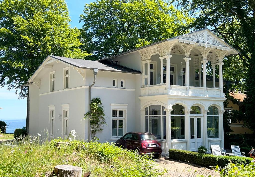 una casa bianca con una macchina parcheggiata di fronte di Meerblick - Villa Achterkerke a Heringsdorf