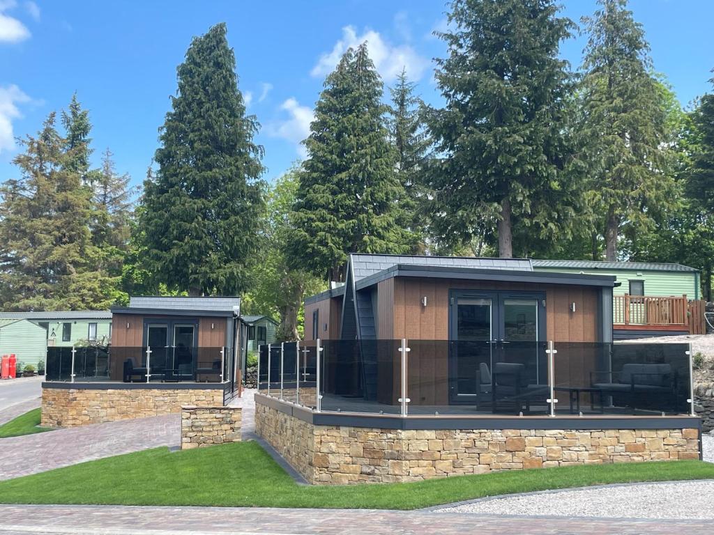 una casetta su un muro di pietra di fronte agli alberi di Martindale & Fusedale Lodge a Penrith