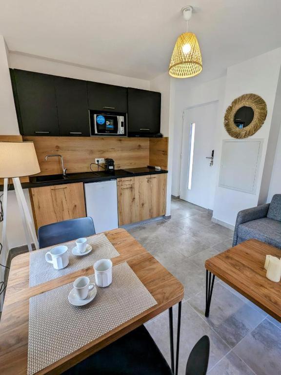 un salon avec une table et une cuisine dans l'établissement Appartement T2 en Corse dans résidence avec piscines proche de Porto Vecchio, à Lecci