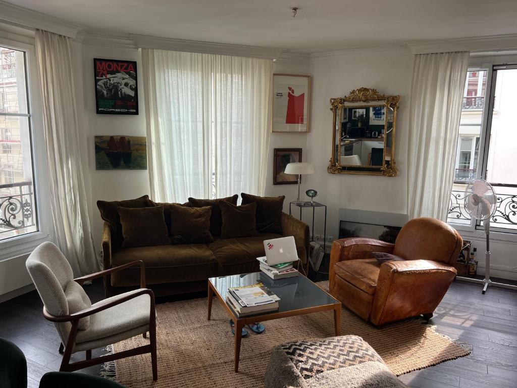 un soggiorno con divano, sedie e tavolo di chambre privée dans superbe appartement parisien ! a Parigi