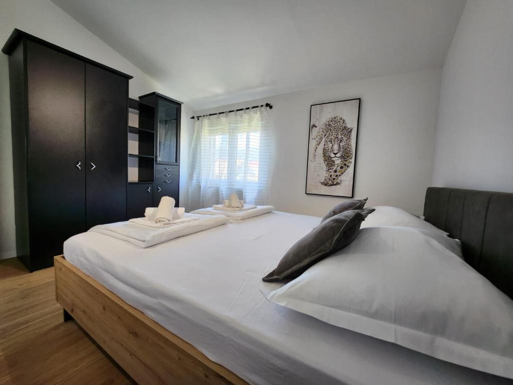duże białe łóżko z 2 poduszkami w obiekcie Apartman LIBRA w mieście Kaštela