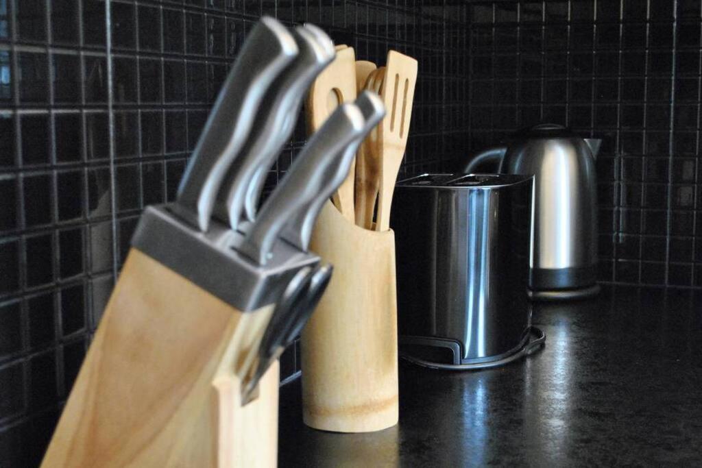 a group of knives in a knife block on a counter at Spacious 2Bed/2Bath Flat next to London Eye in London