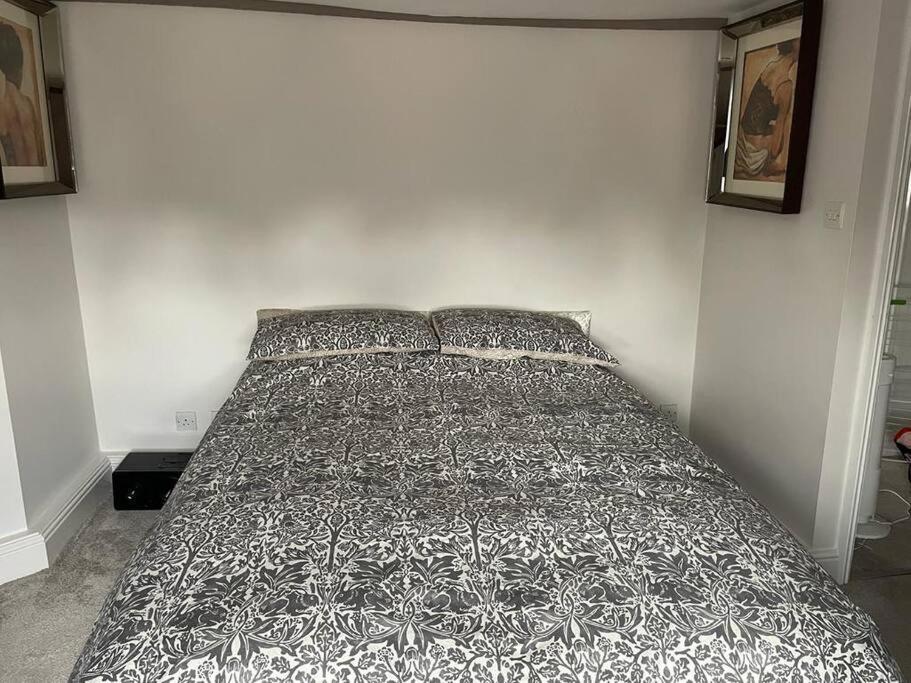 a bed with a black and white comforter in a bedroom at Beautiful 1600’s loft apartment. in Ware
