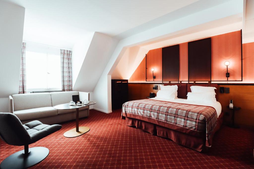 Pokój hotelowy z łóżkiem i krzesłem w obiekcie Les Jardins de Deauville w mieście Saint-Martin-aux-Chartrains