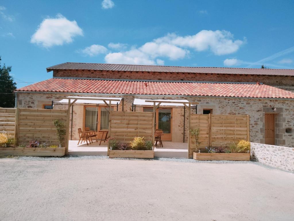 a small house with a patio and a table at Les Granges des Petits Couleurs in Les Épesses