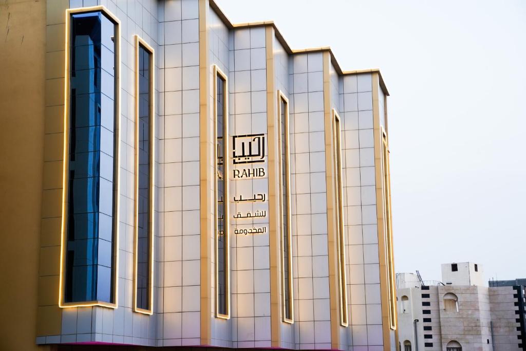 um edifício com um sinal na lateral em فندق رحيب للشقق المخدومة Rahib Suites em Abha
