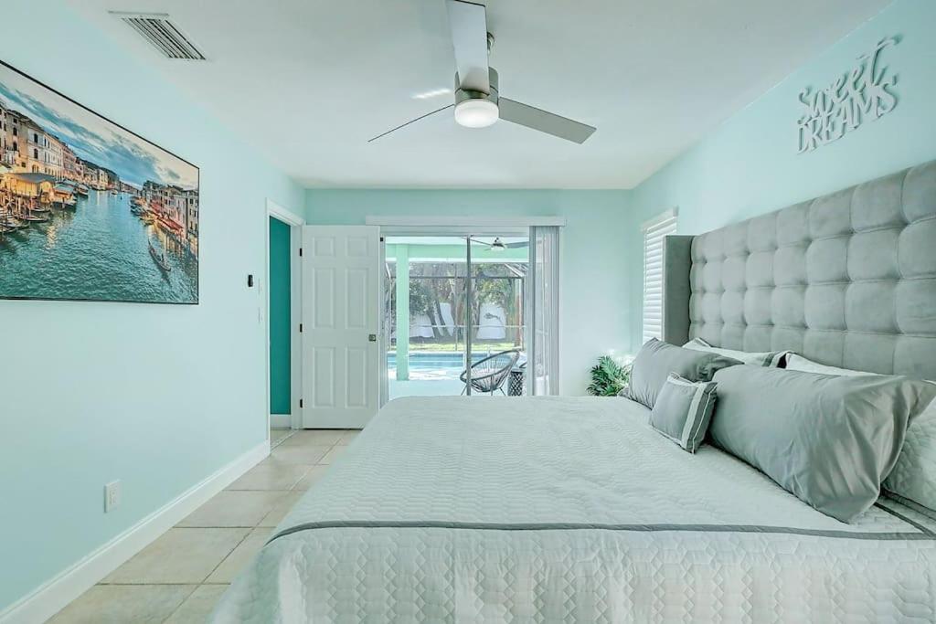 een slaapkamer met een groot bed en een plafondventilator bij Chateau Grove in Port Saint Lucie
