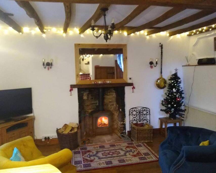 a living room with a fireplace and a christmas tree at Rose Cottage. Richmond, North Yorkshire in Richmond