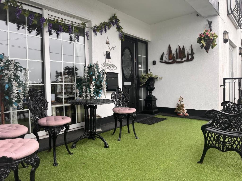 een kamer met stoelen en een tafel met groen tapijt bij The Light House in Galway