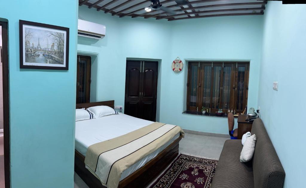 コルカタにあるTeakwood Suite - Nokha Houseのベッドルーム(ベッド1台、ソファ付)
