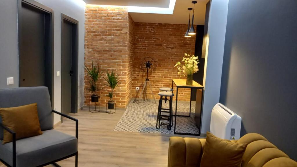 a living room with a couch and a brick wall at Comfort Apartment 2 in Shkodër