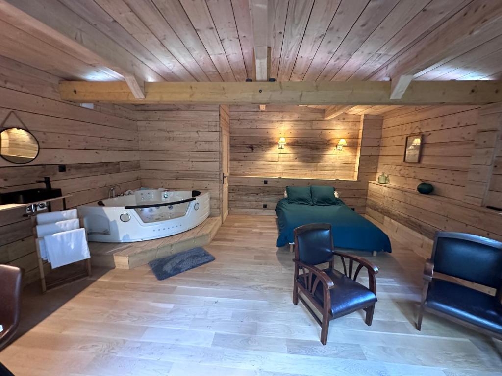 a sauna with a bed and a tub in it at Le Chalet in Les Sorinières