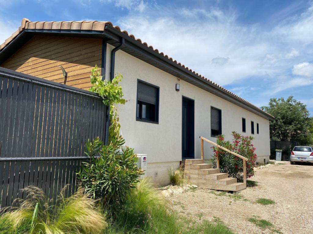 une maison avec une clôture noire devant elle dans l'établissement Maison aux pieds des Alpilles, à Noves