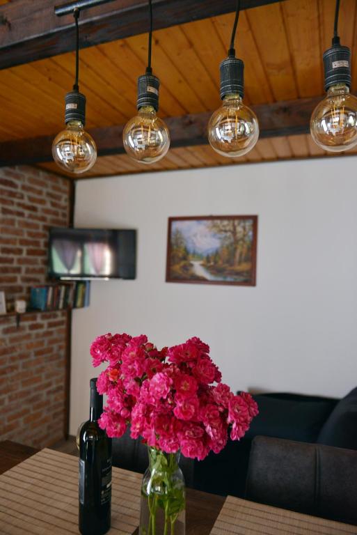 a vase filled with pink flowers sitting on a table at Kuća za odmor Čanić gaj in Gospić