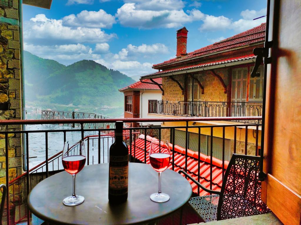 una mesa con 2 copas de vino en el balcón en Elegant Vista Residence, en Metsovo