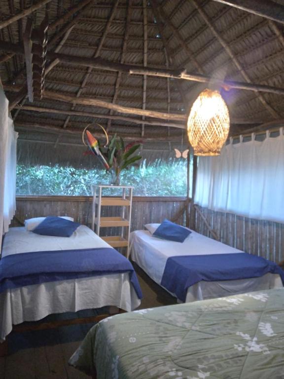 a bedroom with two beds and a chandelier at Cloud forest SAN CARLOS in La Merced