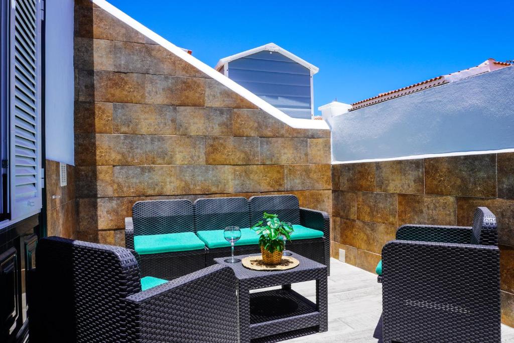 a patio with chairs and a table with a wine glass at La Casita del Sur, Abades in Abades