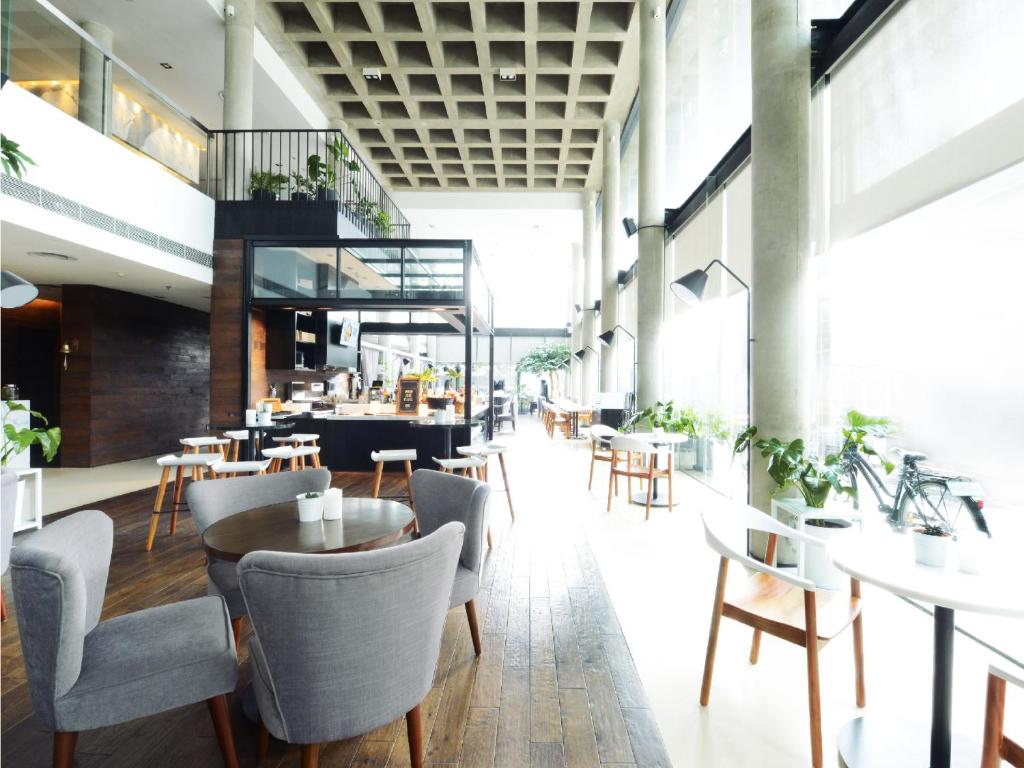 a restaurant with tables and chairs in a room at Morrissey Hotel in Jakarta