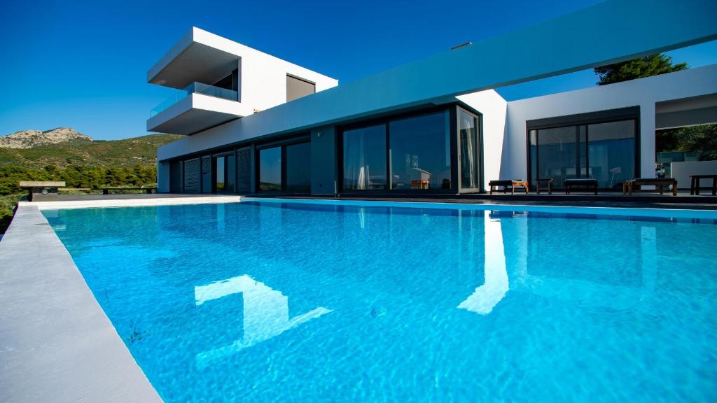 uma piscina em frente a uma casa em Villa Scorpios Attica em Áyioi Apóstoloi