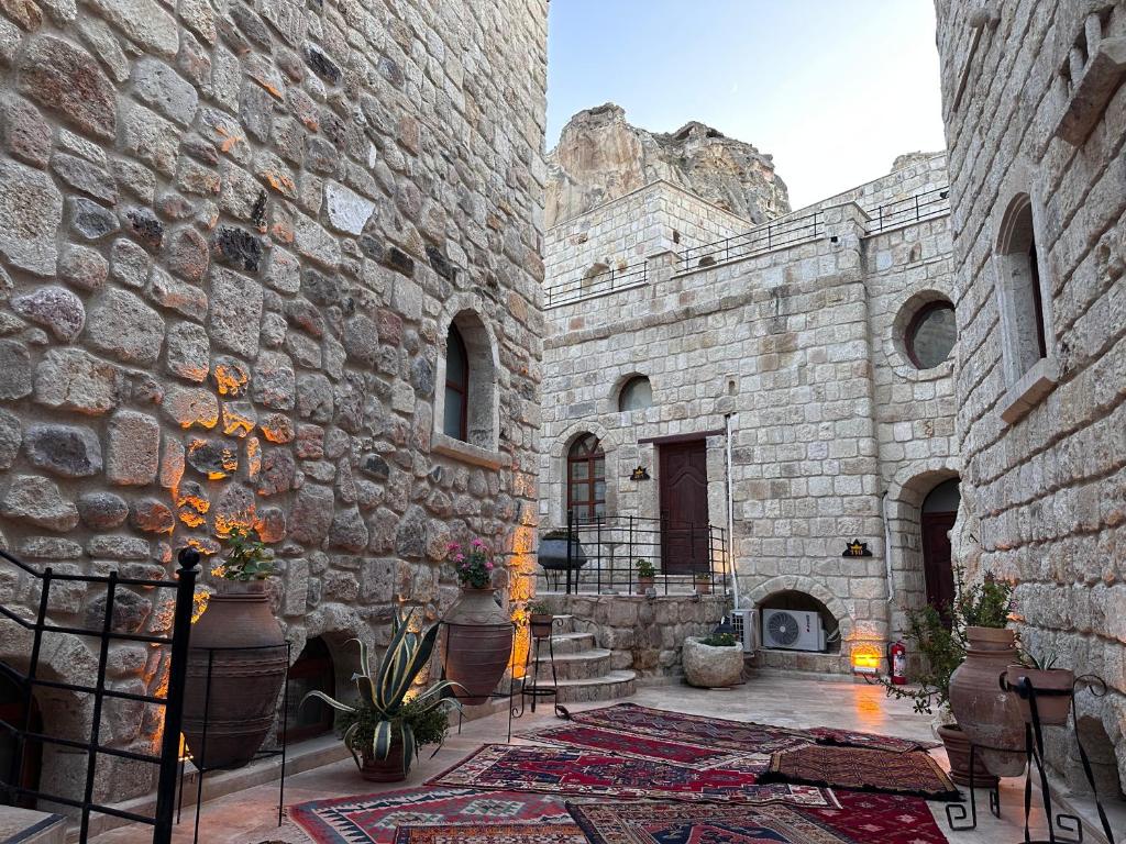 a stone building with a fireplace and a rug at Under Cave Cappadocia in Ürgüp