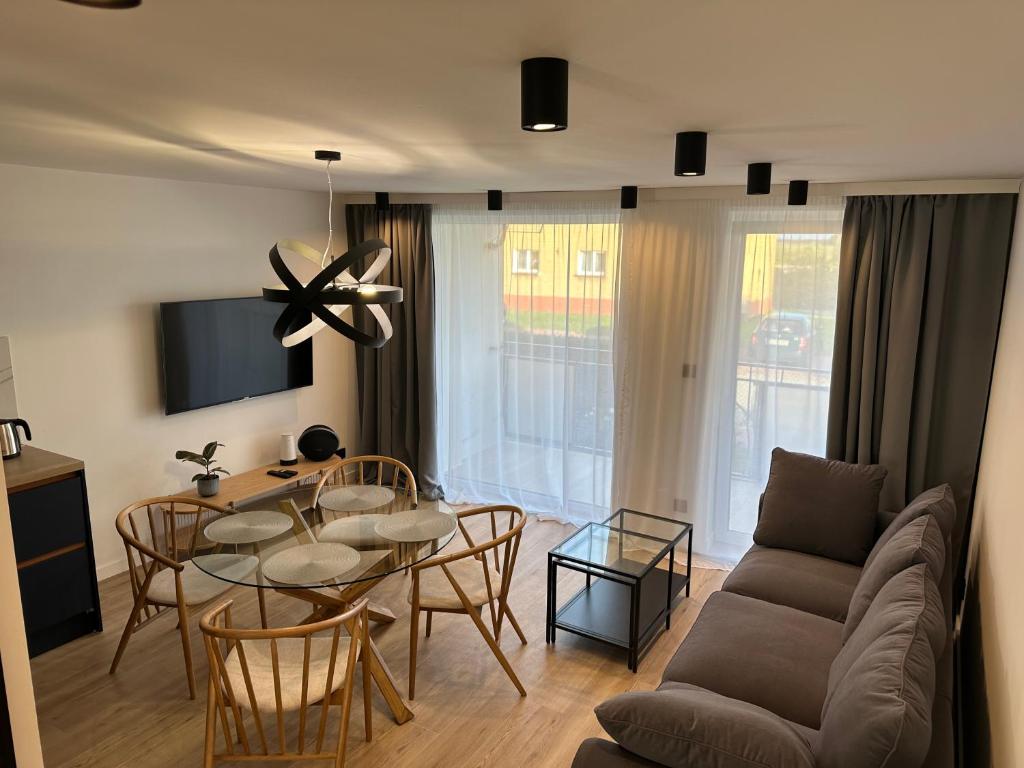 uma sala de estar com uma mesa e uma sala de jantar em Apartament Michałek em Mielno