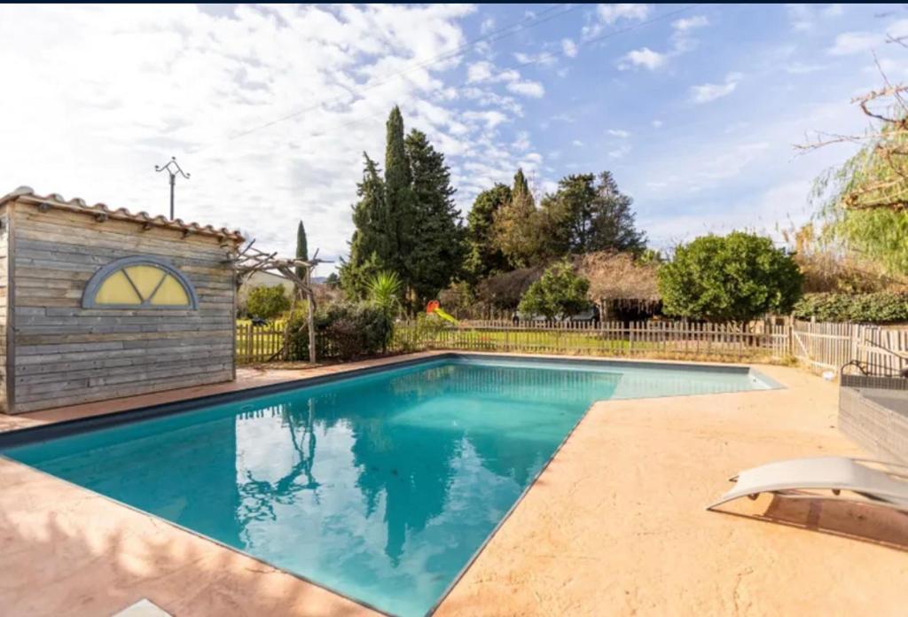 une piscine dans une cour clôturée dans l'établissement Maison de campagne style mas, à Camélas