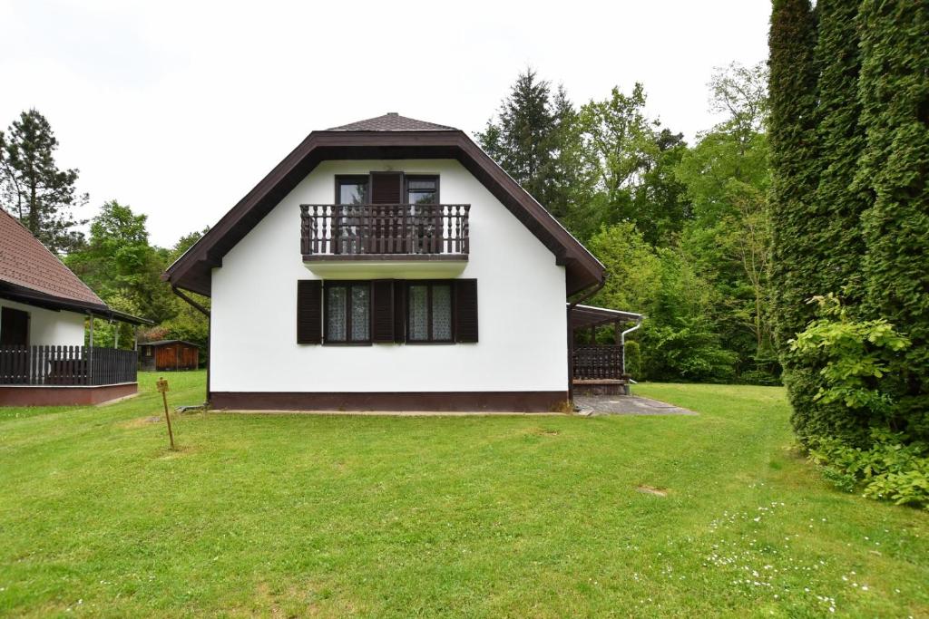 Casa blanca con balcón en un patio en Vadása Nyaraló, en Hegyhátszentjakab