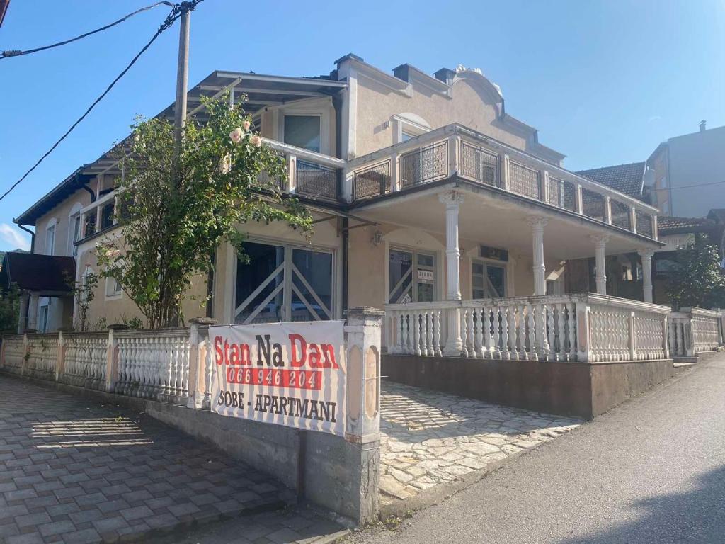 una casa vieja con un cartel delante en Mrkonjić Grad Apartmani, en Mrkonjić Grad