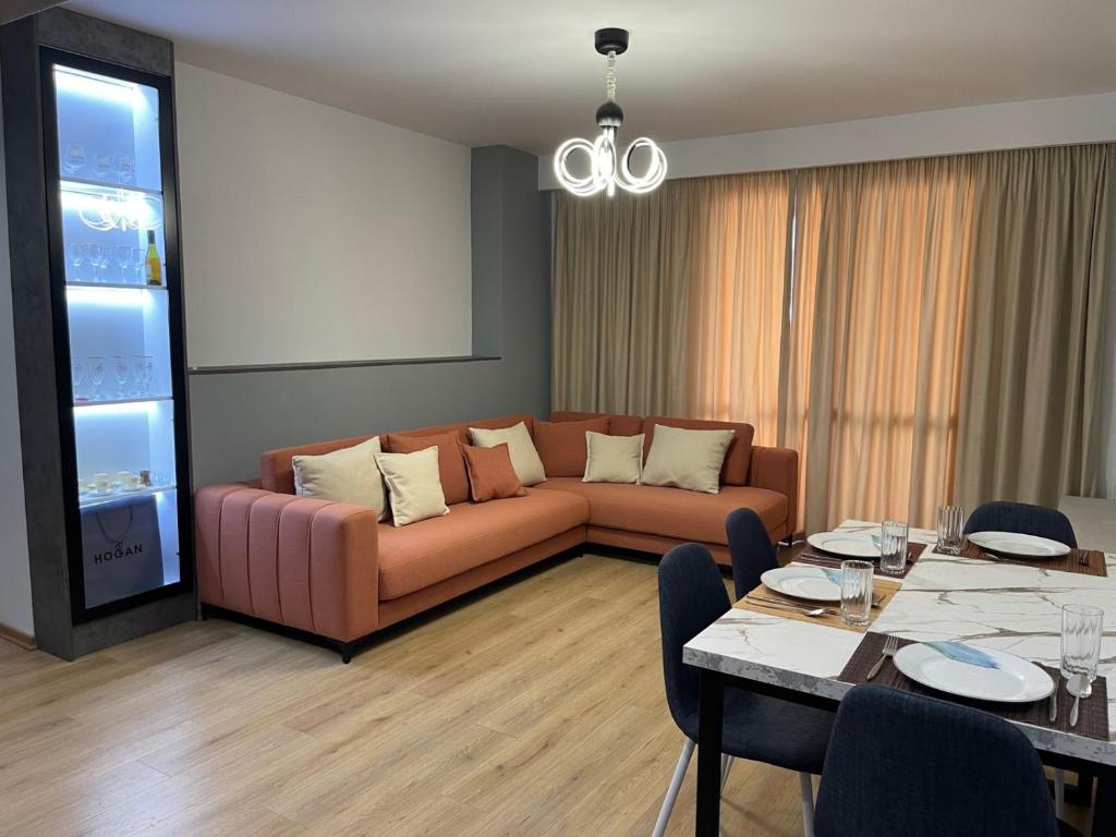 - un salon avec un canapé et une table dans l'établissement Shehapi apartment, à Kavajë