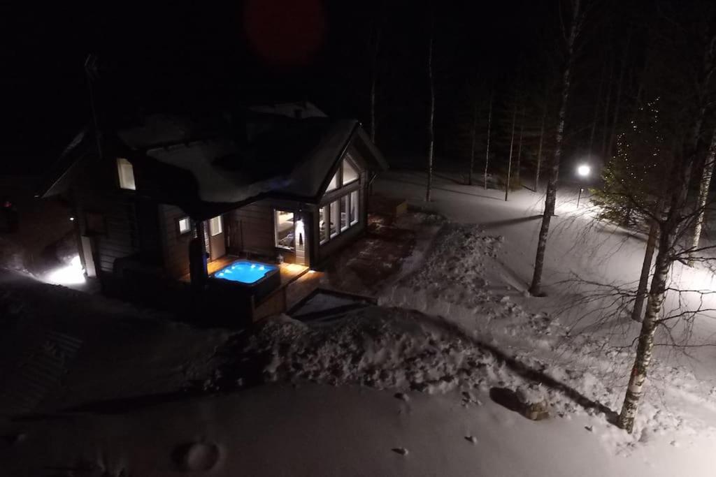 una pequeña cabaña en la nieve por la noche en Your Peace Of Lapland, en Rovaniemi